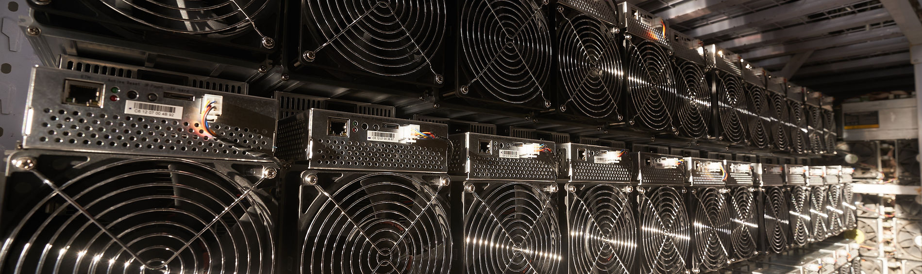 Rows of ASIC miners installed in a secure ASIC miner hosting facility